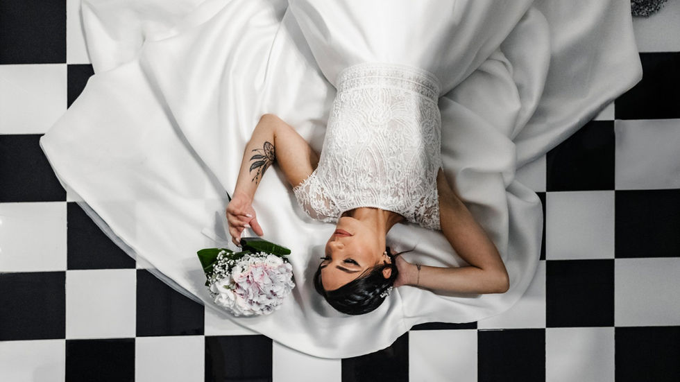 Bride in white wedding dress with bouquet, Matrimonio elegante e romantico, on checkered floor.