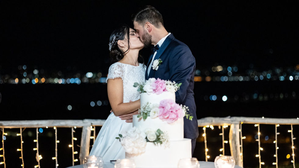 Coppia sposi si bacia davanti alla torta nuziale, Domenico e Angela, festa, Drimage
