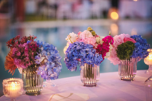 Fiori colorati in vasi d'argento, sfondo piscina. Eleganti decorazioni per evento.