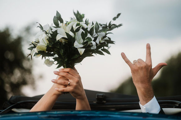 Mani di sposi con bouquet e gesto rock. Fotografia di Drimage Creative studio di Simona Turano Fotografa