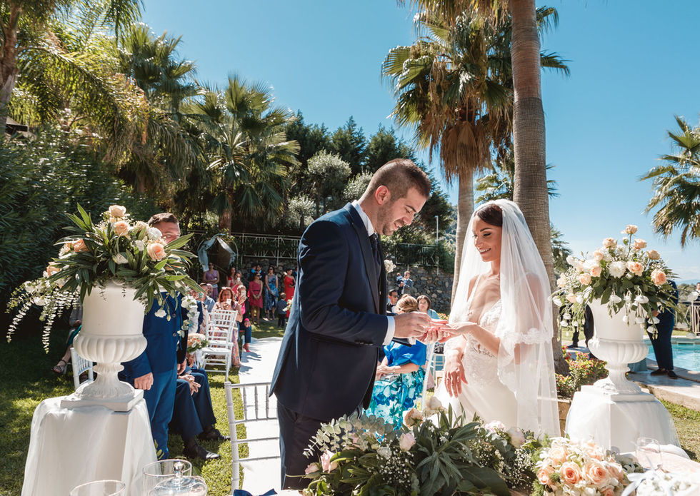 Sposo mette l'anello alla sposa, Matrimonio verde-mare, cerimonia nuziale all'aperto, Drimage