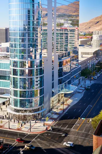 Close-up of SLC Hyatt’s curved glass exterior and surrounding downtown street.