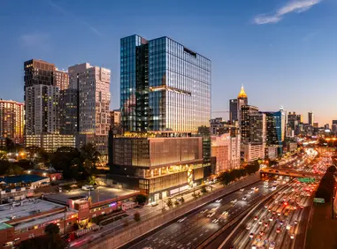 Drone photography near me showing a city skyline and busy freeway during golden hour.