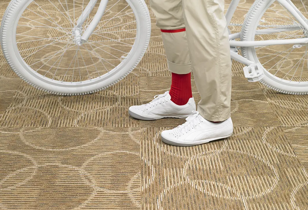 Close-up of red socks, white shoes, and bike tires on carpet for lifestyle product photography.