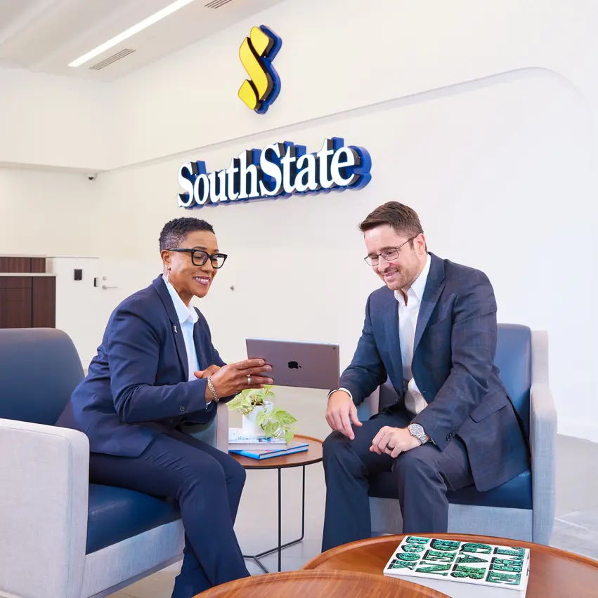 Two professional bankers review a tablet at SouthState Bank.