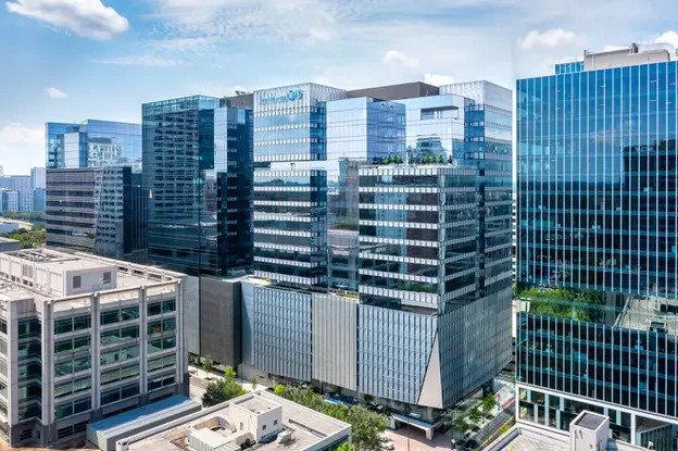 Drone aerial photography of modern glass office buildings reflecting the city skyline.