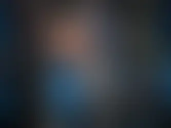 A professional business portrait of an IT technician smiling while managing cables in a server room.