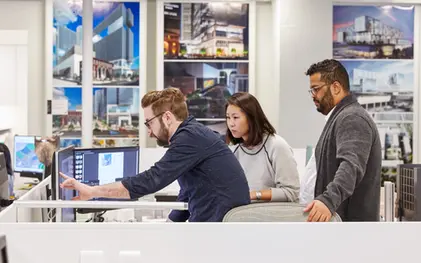 Team members review designs in a bright studio, showing open collaboration in a creative corporate lifestyle space.