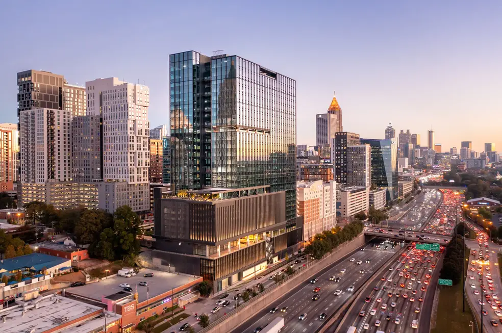 Tall glass tower of Ameris Bank reflecting sky and nearby buildings, shown in a commercial exterior architectural photography image.