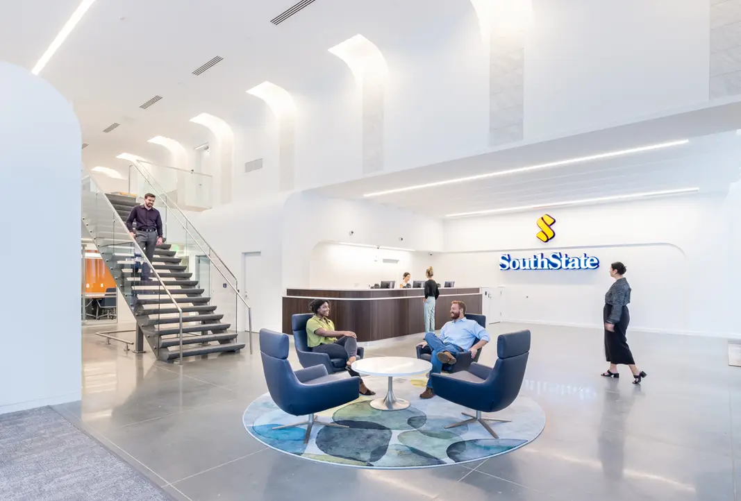 Modern SouthState office with seating area and floating staircase in a bright interior.