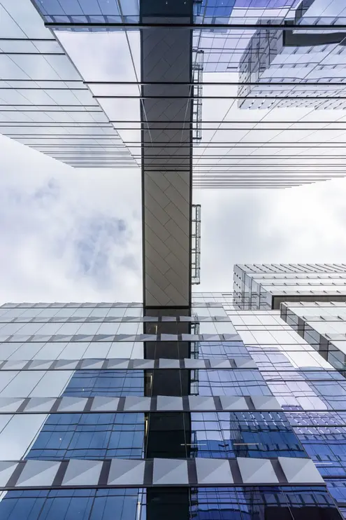 Upward view of Anthem's glass skybridge and modern facade, highlighting symmetry and contemporary commercial exterior architectural design.