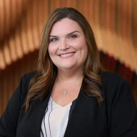 A professional woman in business attire smiling warmly, captured during a corporate headshot photography session.
