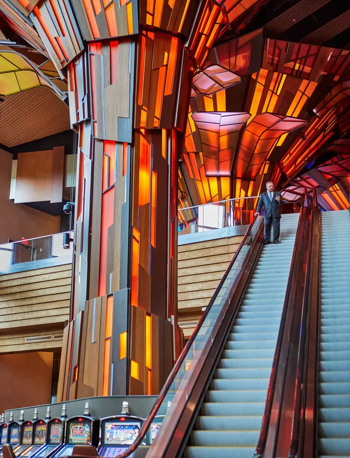 Interior architectural photography showcasing a casino’s dramatic lighting, bold geometric design, and commercial interior escalator installation.