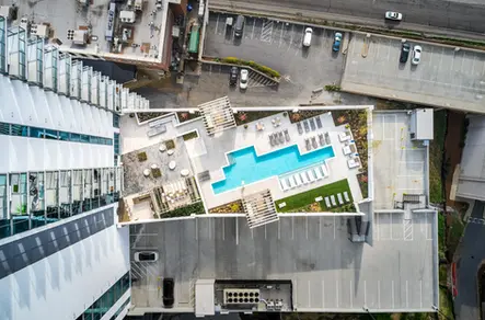 Aerial photography with drones showing a rooftop pool, lounge areas, and nearby buildings.
