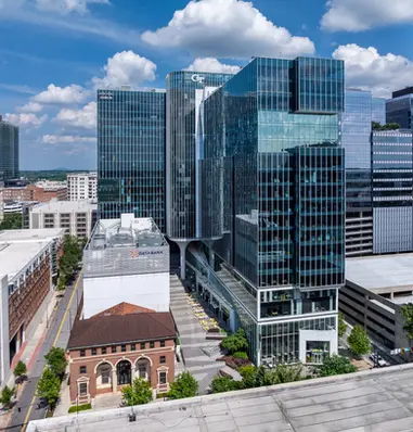 Aerial drone photography of a university tech campus with modern glass buildings and sunny skies.