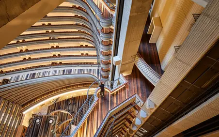 Modern hotel lobby with seating area, polished floors, and front desk captured in vibrant lighting.
