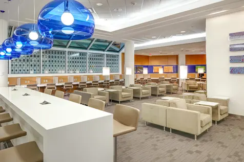 Commercial interior photography of a modern airport lounge, emphasizing seating arrangements and bold lighting for a welcoming interior architecture.