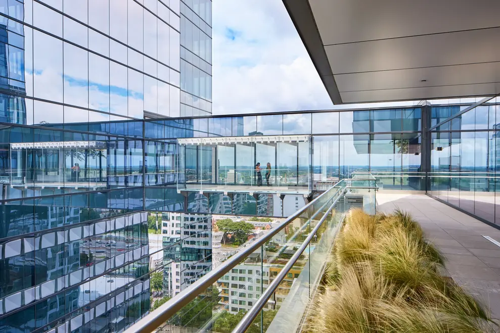 Elevated glass walkway with people inside at Anthem's modern office building, photographed for exterior architectural design documentation.