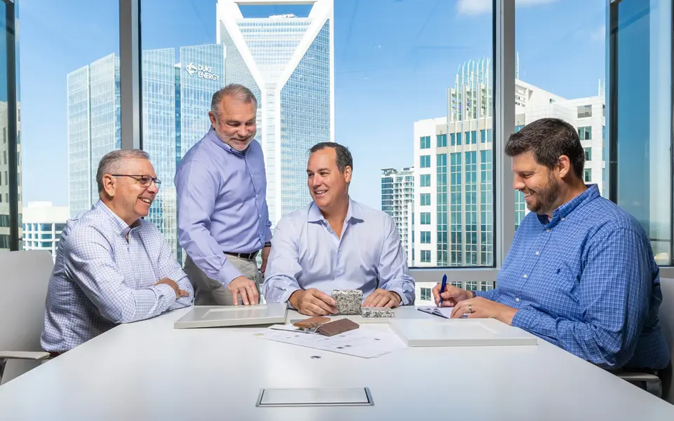 Business professionals meet at a boardroom table with city views, showing leadership in corporate lifestyle settings.