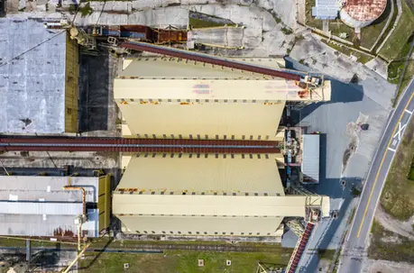 Drone aerial photography showing an industrial complex with large rooftops and pipelines.