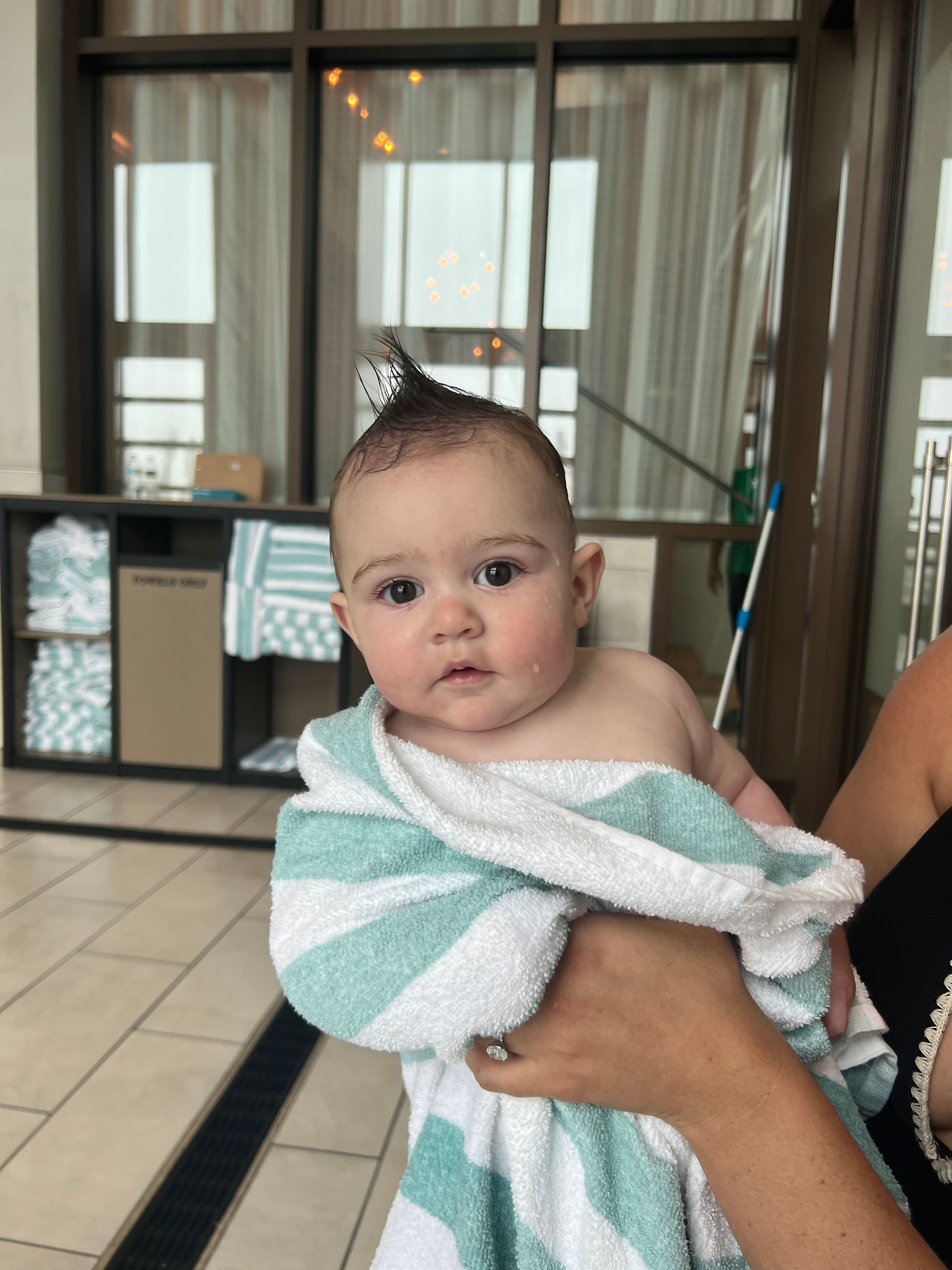 baby wrapped in a towel after swimming with a mohawk 