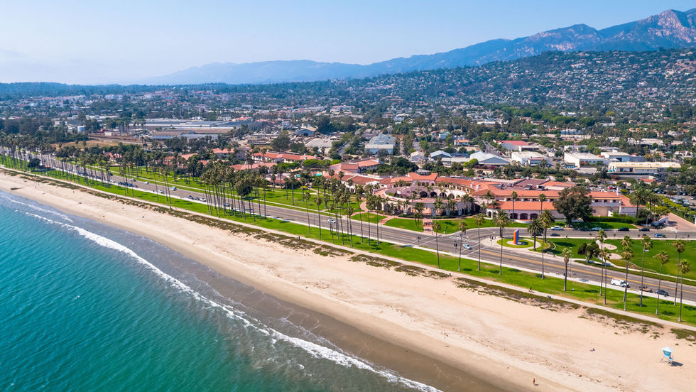 aerial view over the coastline outside the Hilton Santa barbara resort with palm trees lining the roadway in to the city