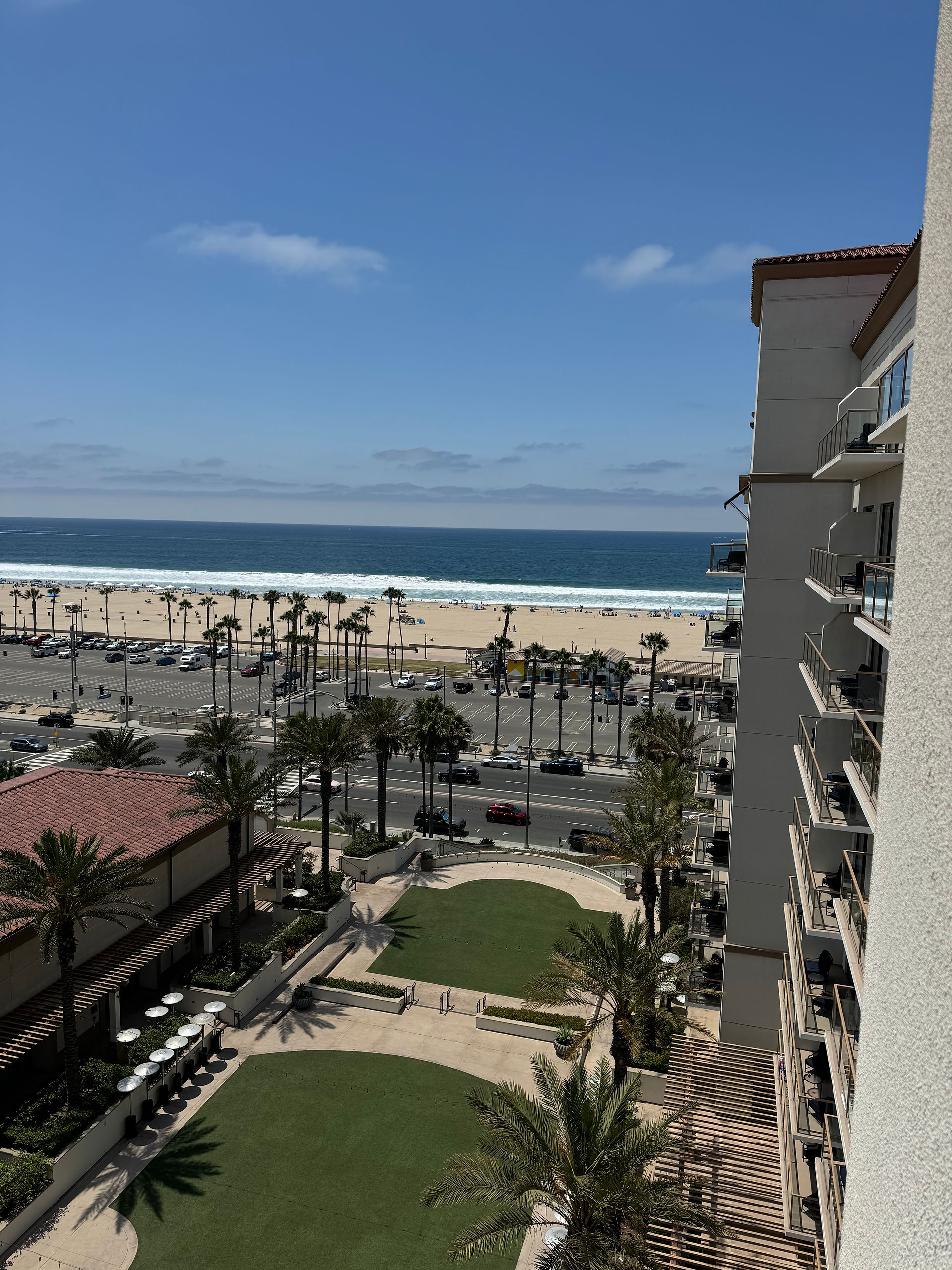 view of the beach and hotel courtyard from the balcony window