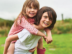 kız kardeşini sırtına alan erkek çocuk