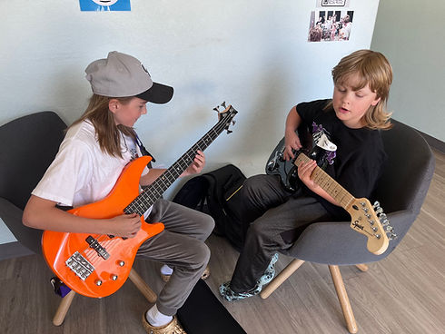 Two Students In Lobby Playing Guitar