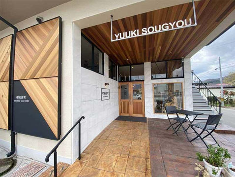 スタンプコンクリートで施した床面とモルタル造形の壁面の建築図書館の出入口