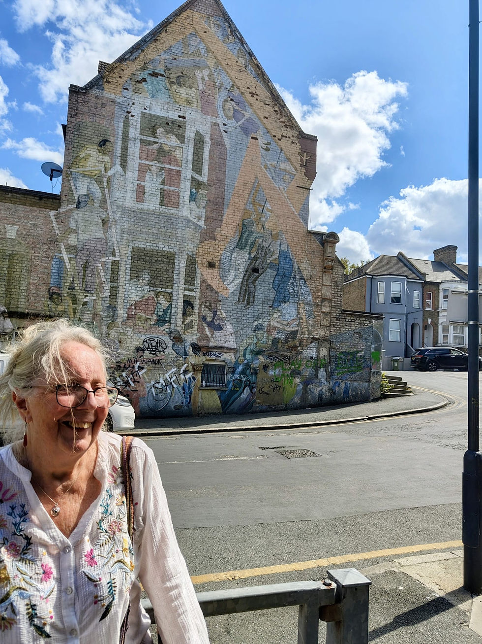 Carol with the Floyd Road community mural, faded but still vibrant