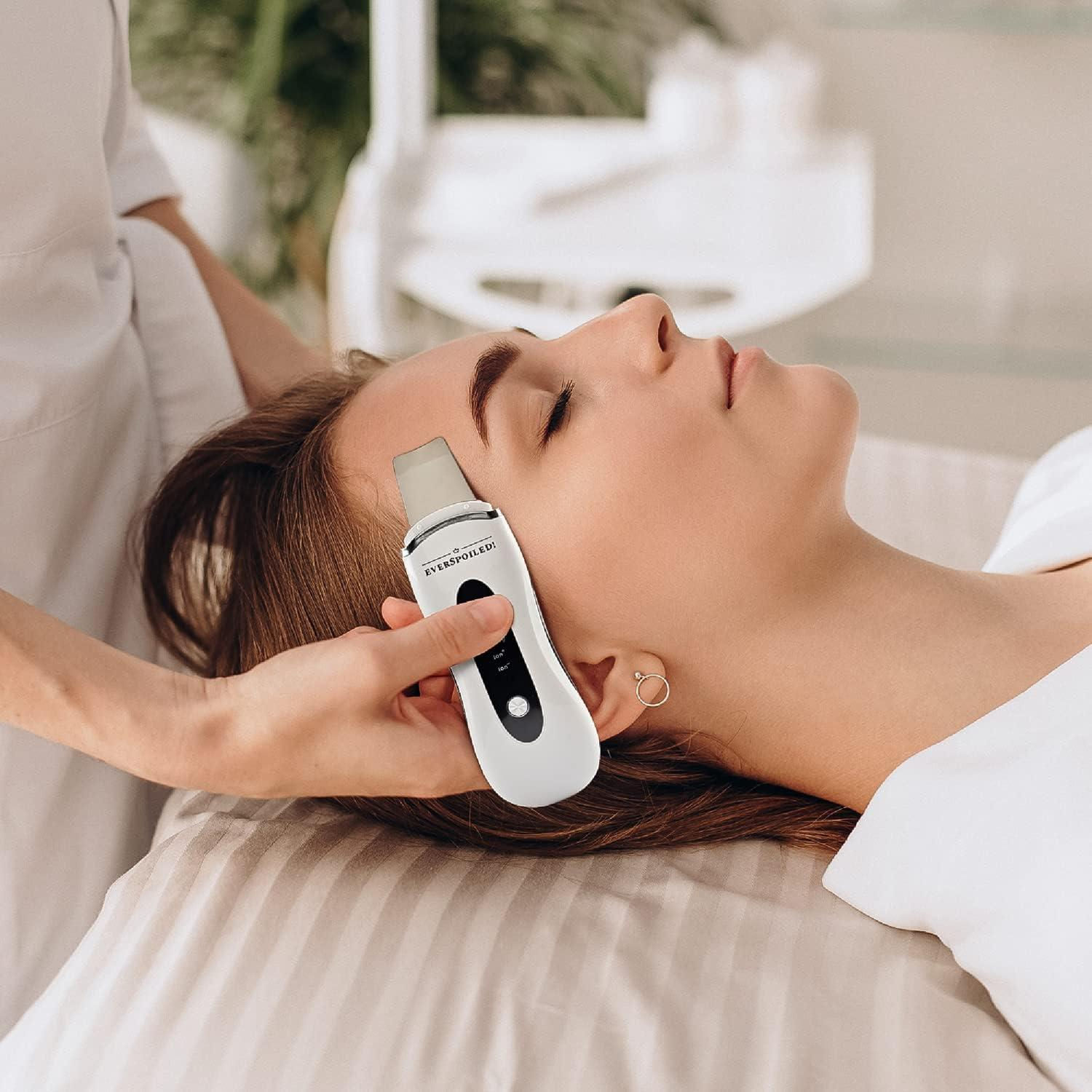 Mujer recibiendo limpieza facial con exfoliador ultrasónico en salón de belleza.