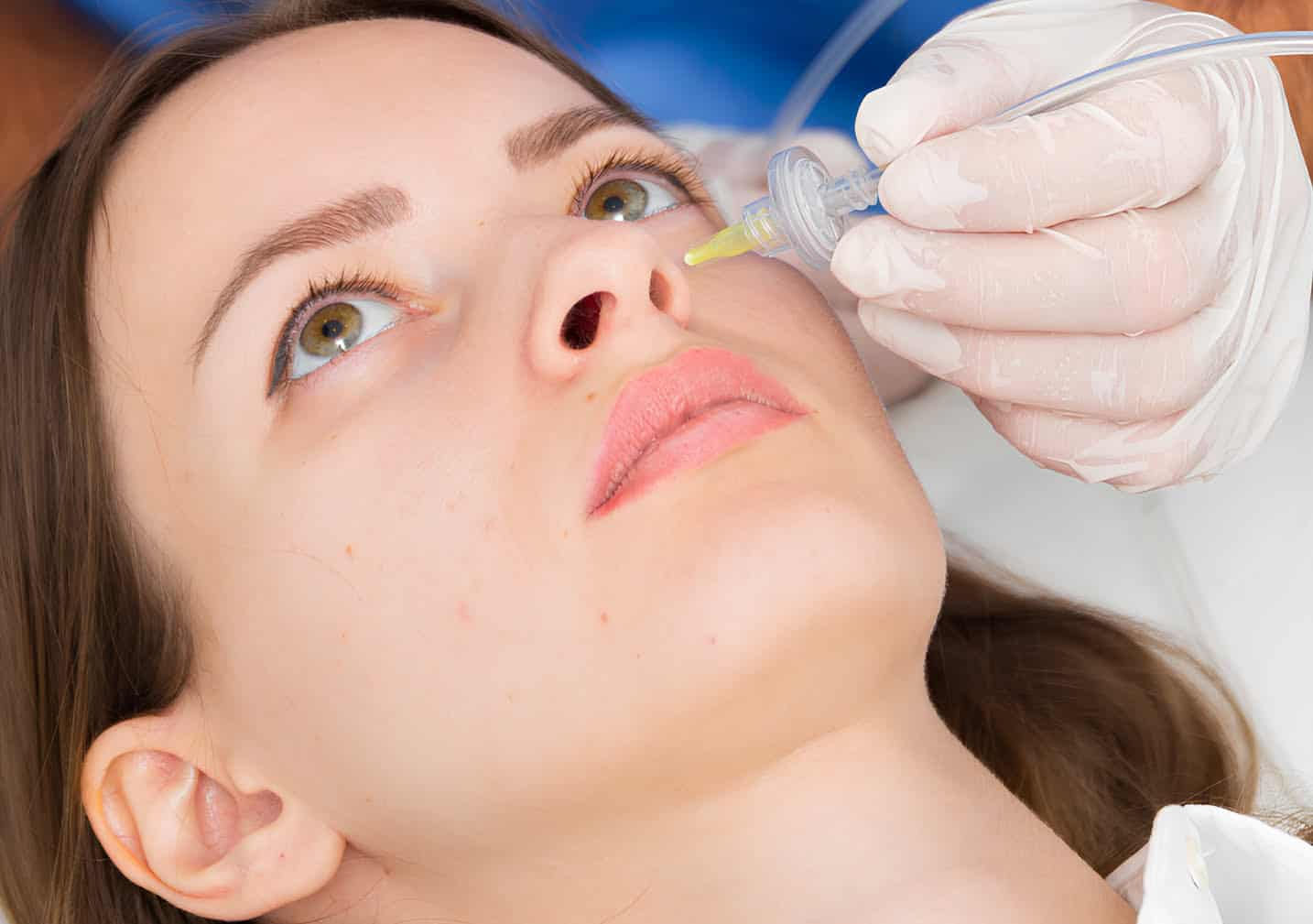 Mujer recibiendo mascarilla facial en clínica.