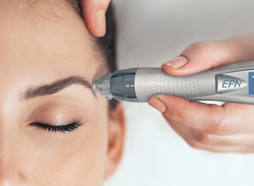 Mujer relajada recibiendo tratamiento facial con dispositivo en spa.