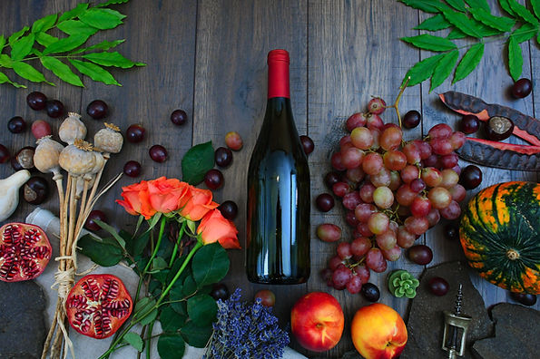 bottlw of wine, flowers, fruits, wooden background