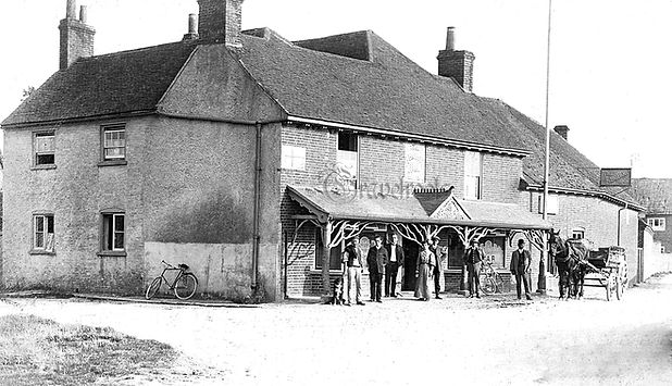 A black and white photograph of The Anchor pub in Sidlesham taken over 100 years ago, showing the original building and surroundings, capturing its historic charm.