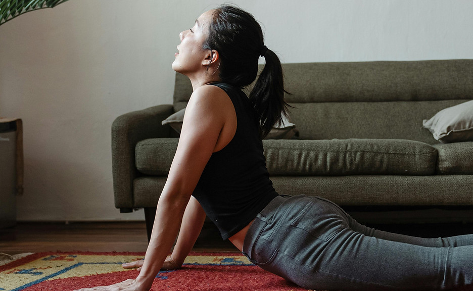 Woman stretching calmly indoors, representing recovery and nervous system reset through holistic wellness