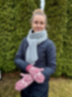 kobieta w ogrodzie prezentuje żakardowe rękawice zrobione na drutach