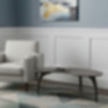 Wood Castle Tibro dark oval coffee table with curved legs beside armchair, model 0950