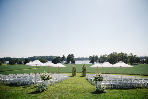 Wedding venue setup with guest seating and umbrellas