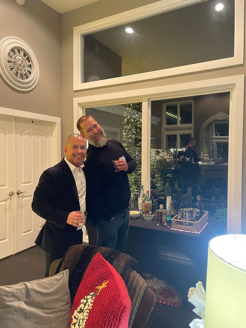 Two smiling men at an evening gathering