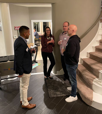 Four colleagues converse in a building hallway