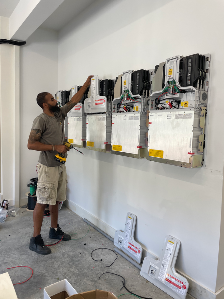 Newport Solar technician installing batteries