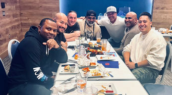 Group of men smiling at a table of food