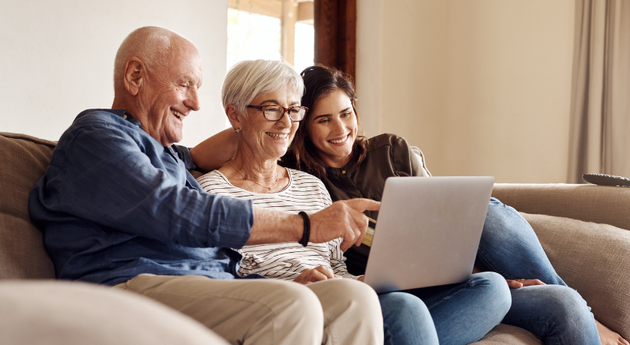 Smiling family looking at a laptop