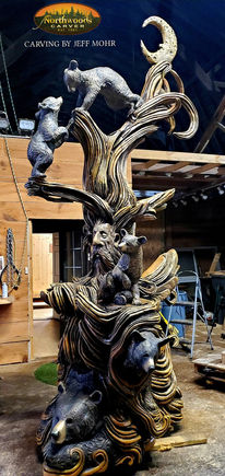Intricate wood carving: monkeys climbing tree, figures at base
