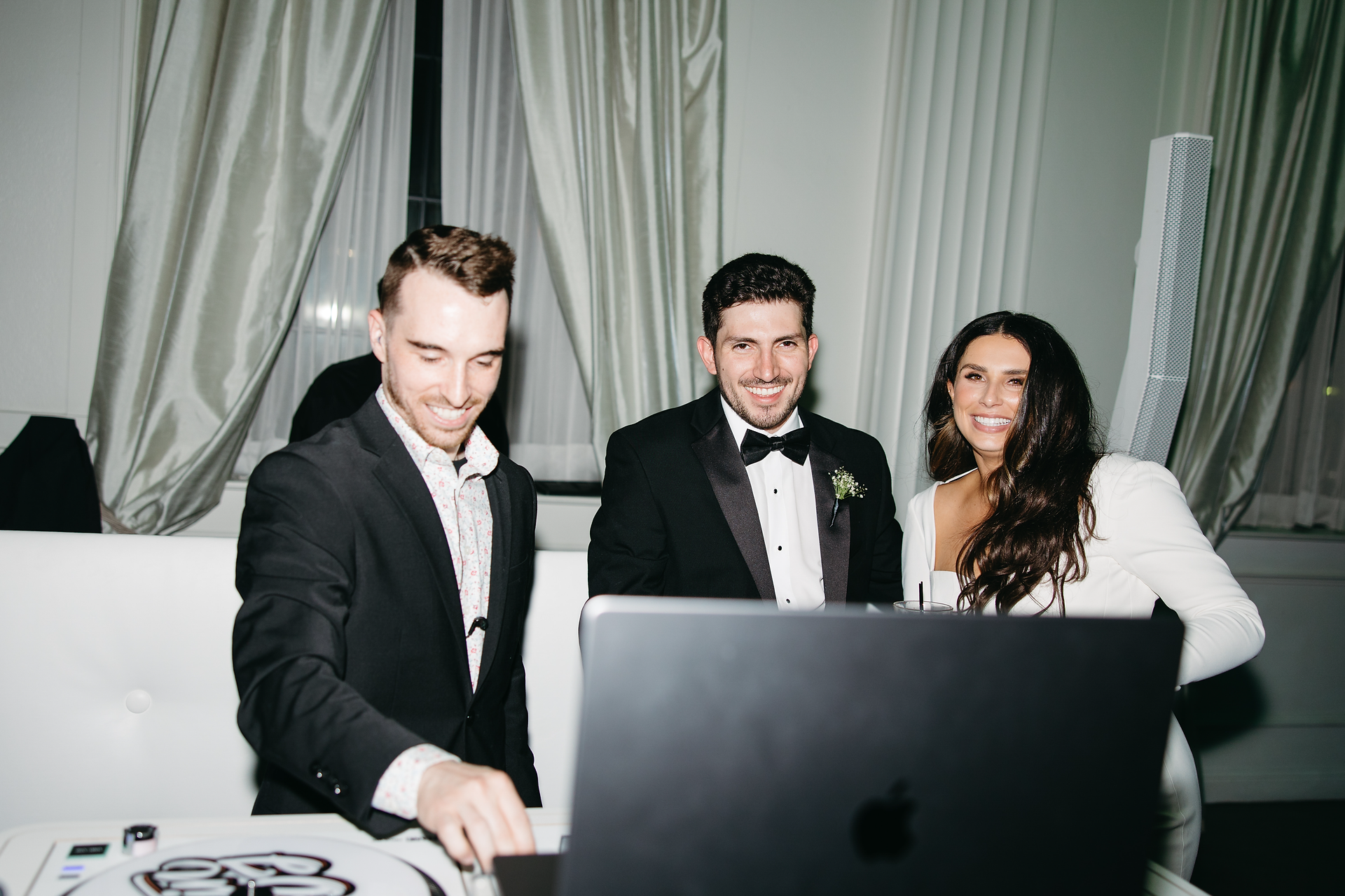 wedding dj with the bride and groom behind the dj booth