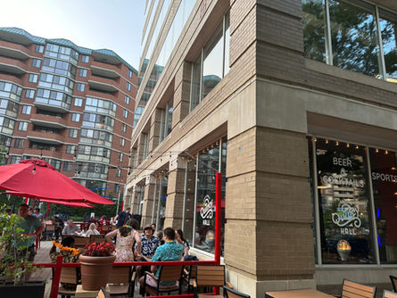 Outdoor cafe patio with people under red umbrellas