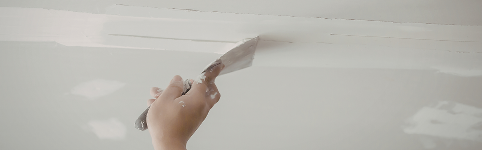 Hand applying plaster or filler to wall