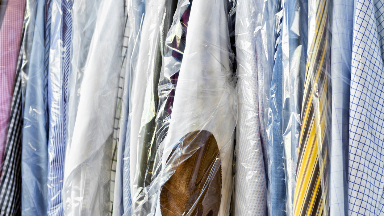 Clean shirts and ties hanging, wrapped in plastic, ready for pickup
